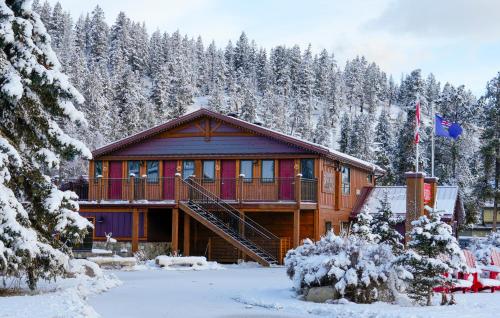 a log cabin in the snow with snow covered trees at Bear Hill Lodge in Jasper