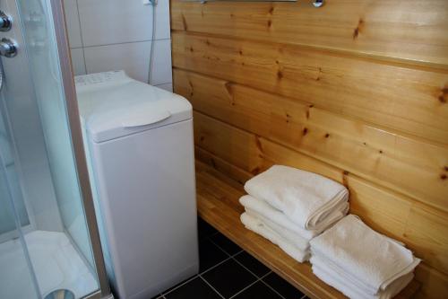 a bathroom with a stack of towels next to a shower at Aaroybukt Guesthouse in Årøybukta
