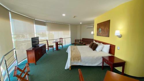 a hotel room with a bed and a balcony at Hotel Enterprise Inn Poliforum in León