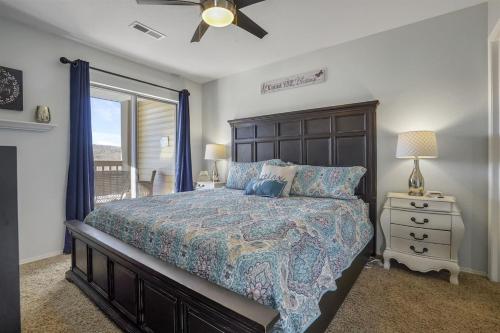 Un dormitorio con una cama y un ventilador de techo. en The Cove 4-5 By SDC, Big Deck, Pool, Hot Tub, By Lake, en Branson