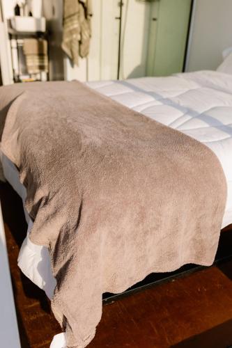 a blanket on the side of a bed at Container Experience in Jacareí