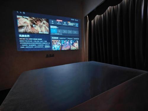 a table in a room with a tv on the wall at Mangrove Bay Riverside Hill Riverview B&Bl紅樹灣河畔山河景民宿l豪華五房六床高層山景河景l離華發商都商場和港珠澳大橋及拱北澳門關口10分鐘l離橫琴長隆王國25分鐘l樓下北山古城食街 in Zhuhai