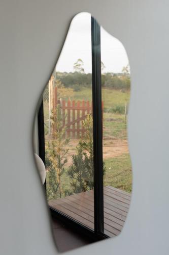 a window with a view of a wooden deck at Container Experience in Jacareí