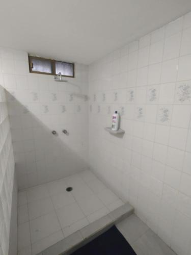 a white tiled shower with a window in a bathroom at Santafe Suites in Hermosillo