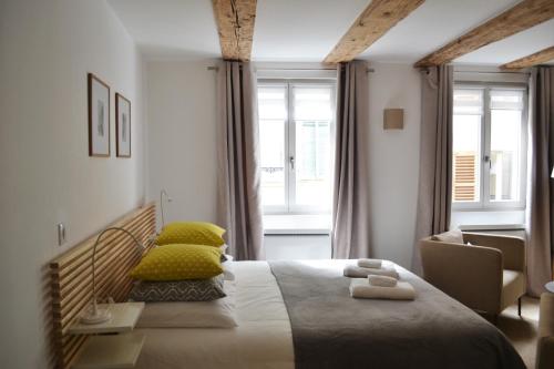 une chambre avec un grand lit avec des oreillers jaunes dans l'établissement Studio Maison Verte Colmar Centre, à Colmar