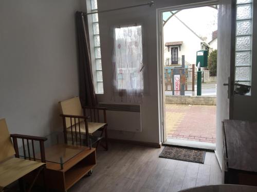 a room with an open door with a table and chairs at Chez Nahiko STUDIO Paris Massy Palaiseau in Palaiseau