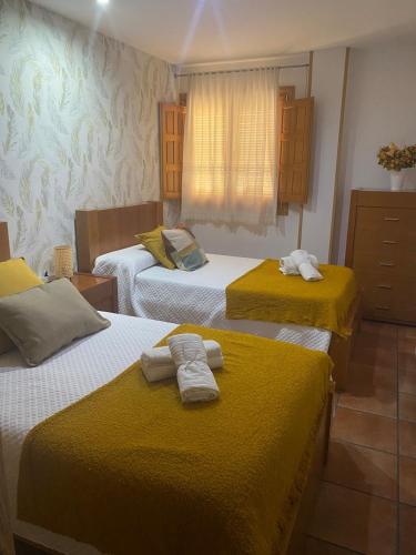 a room with three beds with towels on them at El palacio de Juana in Tordesillas