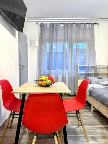 a dining room table with red chairs and a bowl of fruit at Vesna Studios in Ljubljana