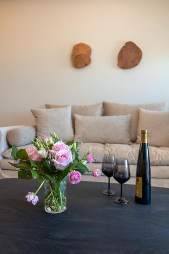 a table with a vase of flowers and two wine glasses at Depalyma Suites in Emporio Santorini
