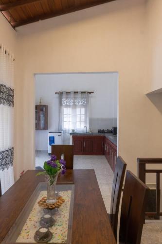 cocina y comedor con un jarrón de flores sobre una mesa en Spacious Entire House in Colombo, en Moratuwa