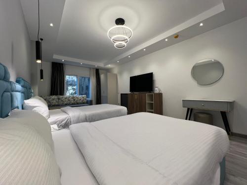 a hotel room with two beds and a television at Onyx Pyramids Boutique Hotel in Cairo