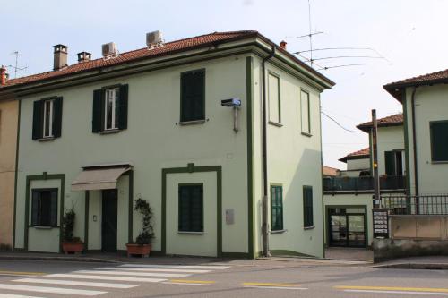 a white building with black windows on a street at Residenza Acqua Terra Fuoco in Como