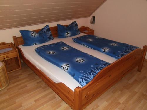 Bett mit blauer Bettwäsche und blauen Kissen in der Unterkunft Weingut u. Gästehaus Menten in Briedel