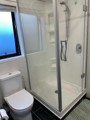 a bathroom with a shower and a toilet at Waterfront studio unit near Auckland Airport in Auckland