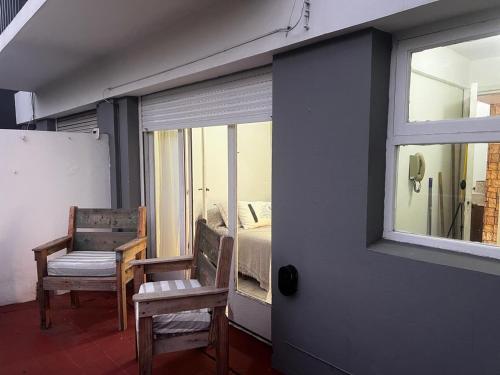 een kamer met een raam en een slaapkamer met een bed bij Alfonsina Departamento cerca del mar in Mar del Plata