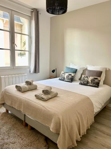 une chambre avec un grand lit avec deux serviettes dessus dans l'établissement Voyage à la plage, à Deauville