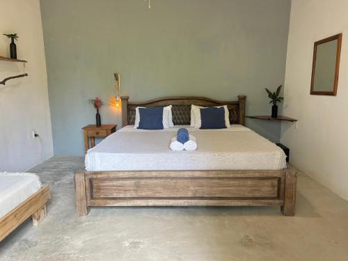 a bedroom with a large bed with two pillows at Pachamama Tropical Garden Lodge in Carmen