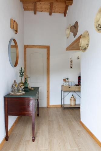 a room with a wooden table and a mirror at Villae Ceira & Serra Refúgio com Piscina junto à Serra da Lousã in Lousã