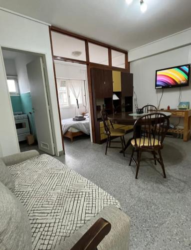 a living room with a table and chairs and a bedroom at Cómodo y excelente ubicación in Mar del Plata