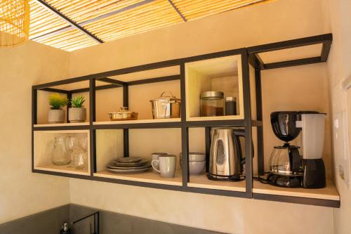 a shelf with pots and pans and a coffee maker at Tierra Mistú in Ginebra