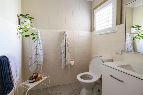 Merduka Sands 4 - Cozy charming cottage في Brooms Head: حمام مع مرحاض ومغسلة