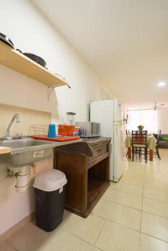 a kitchen with a sink and a refrigerator at Casa Dorada in Santa Cruz Huatulco