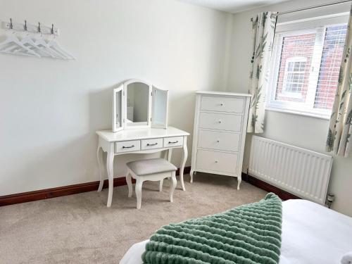 a bedroom with a dressing table and a mirror at Bowling Green cottage in Wheaton Aston
