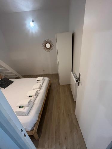 Cette petite chambre comprend un lit et une porte. dans l'établissement BERBERE 13 people Paris Place de la Nation, à Paris