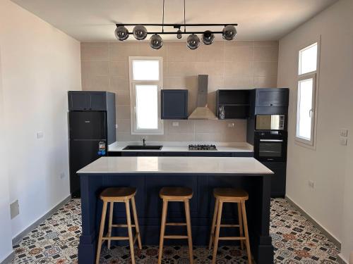 a kitchen with a island with two bar stools at Nomads Hostel in Dahab