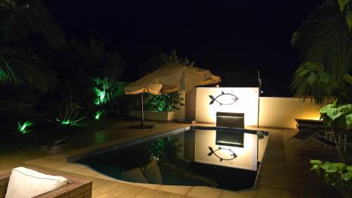 a swimming pool at night with an umbrella at El Jardín Secreto in Trinidad