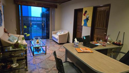a living room with a table with a laptop on it at El Jardín Secreto in Trinidad