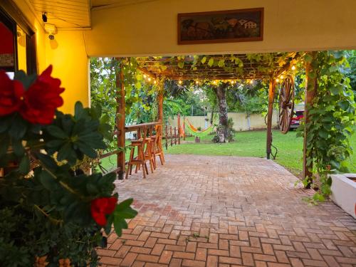 an outdoor patio with chairs and a pergola at El Jardín Secreto in Trinidad