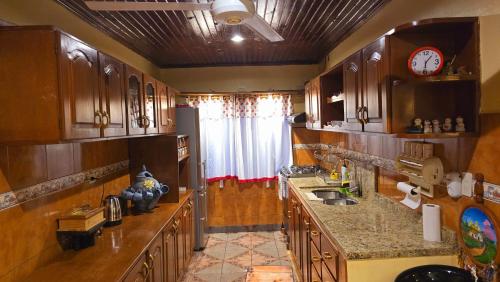 a kitchen with wooden cabinets and a clock on the wall at El Jardín Secreto in Trinidad