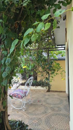a white bench sitting on a patio under a tree at El Jardín Secreto in Trinidad