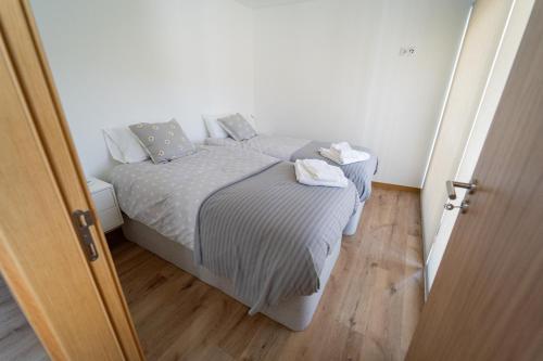 a small bedroom with a bed and a wooden floor at Casa do Cabecinho in Pampilhosa da Serra