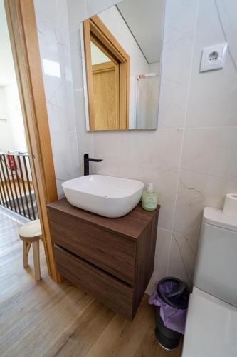a bathroom with a white sink and a mirror at Casa do Cabecinho in Pampilhosa da Serra
