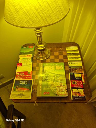 einen Tisch mit einer Lampe und Büchern darauf in der Unterkunft La Churita in San Salvador de Jujuy