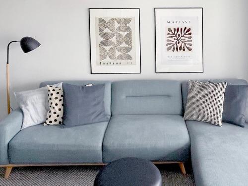 a living room with a blue couch and two pictures at Stylish Executive City Pad w Parking and Pool in Perth