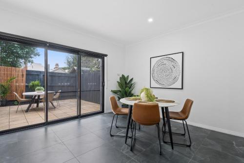 a dining room with a table and chairs at Sleek 2-Bed Terrace near Local Parks in Melbourne