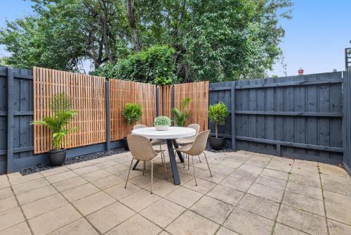 a patio with a table and chairs and a fence at Sleek 2-Bed Terrace near Local Parks in Melbourne