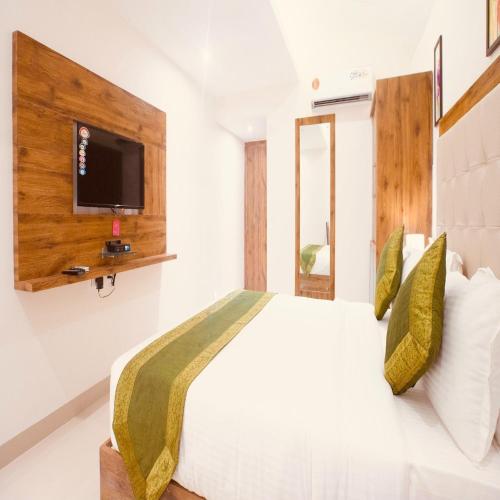 a bedroom with a bed with a tv on the wall at Hotel Crystal Inn Plaza Delhi Airport in New Delhi