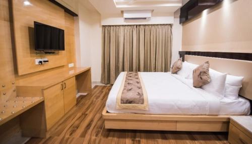 a hotel room with a bed and a television at Hotel Crystal Inn Plaza Delhi Airport in New Delhi