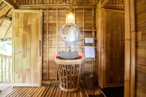 a bathroom with a sink in a wooden cabin at Aura Svarga - Swarga House in Selat
