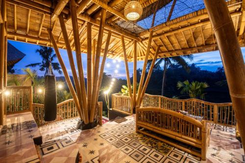 a large room with wooden benches and a wooden ceiling at Aura Svarga - Swarga House in Selat