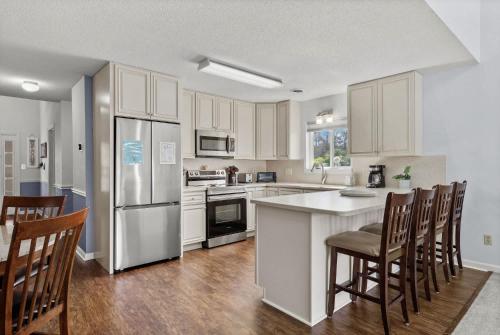 a kitchen with white cabinets and a kitchen island with chairs at 34j GCR-Ortiz Oasis in Myrtle Beach