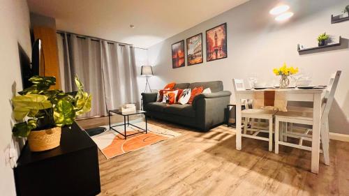 a living room with a couch and a table and a desk at Entire 2BR City Centre Skyline apartment with parking in Birmingham