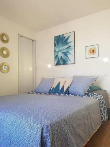 une chambre avec un grand lit avec des draps bleus dans l'établissement Paris & Disney - LES BORDS DE MARNE, à Meaux