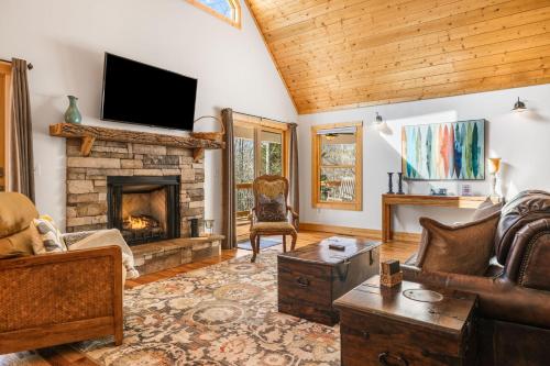 a living room with a fireplace and a tv at Serenade Collection by Carolina Mornings in Hendersonville