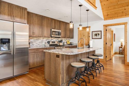 a kitchen with wooden cabinets and a stainless steel refrigerator at Serenade Collection by Carolina Mornings in Hendersonville