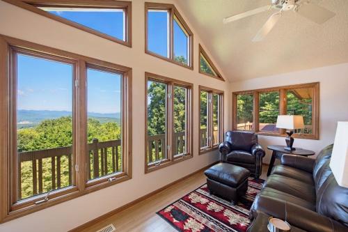 a living room with a couch and chairs and windows at Sunset Peaks by Carolina Mornings in Asheville